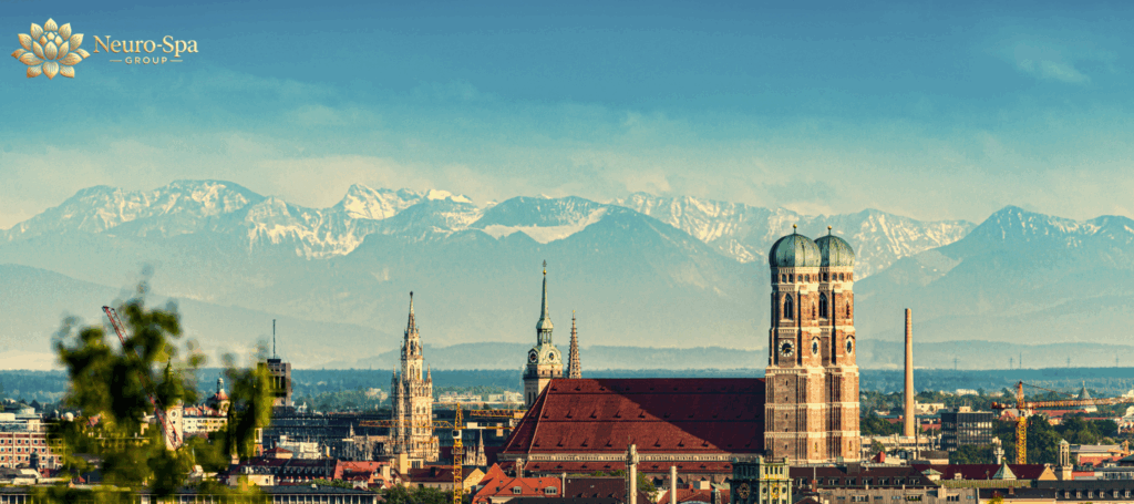 Panoramablick über München mit Frauenkirche und Alpen im Hintergrund – Standort der Neuro-Spa Group mit TPS, rTMS und Neo TMS.