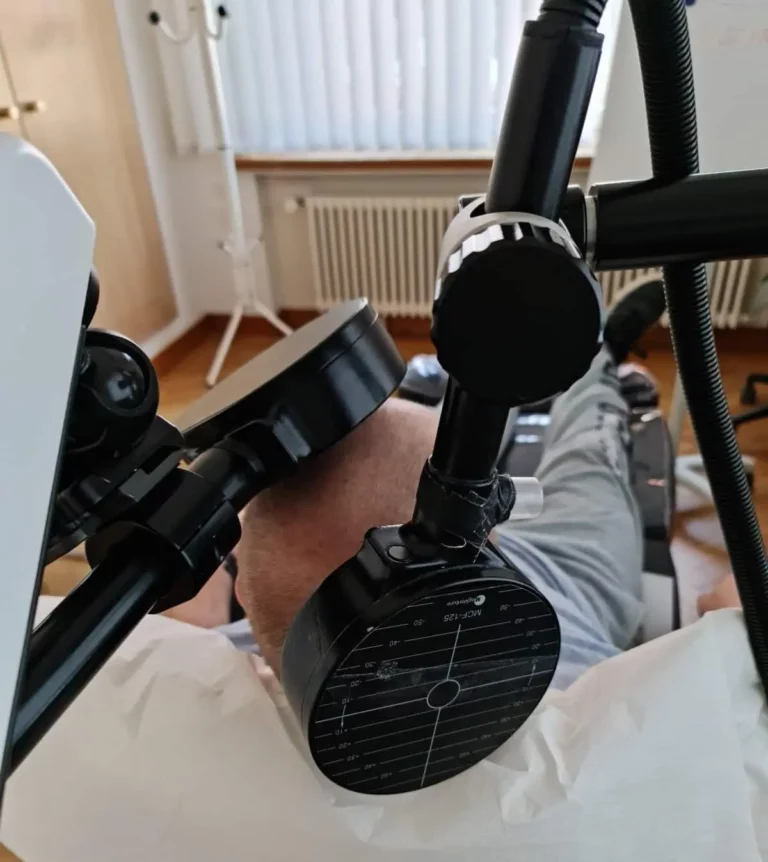 Patient während einer rTMS/Neo TMS-Behandlung in der Neuro-Spa Group mit Magnetspule am Kopf.